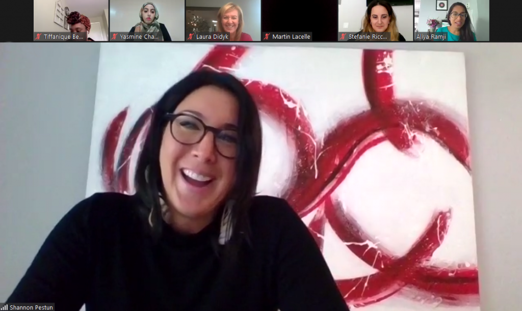 A screenshot of Shannon Pestun smiling during the webinar and sitting in front of an abstract art piece with images of other webinar participants in a row at the top of the screen