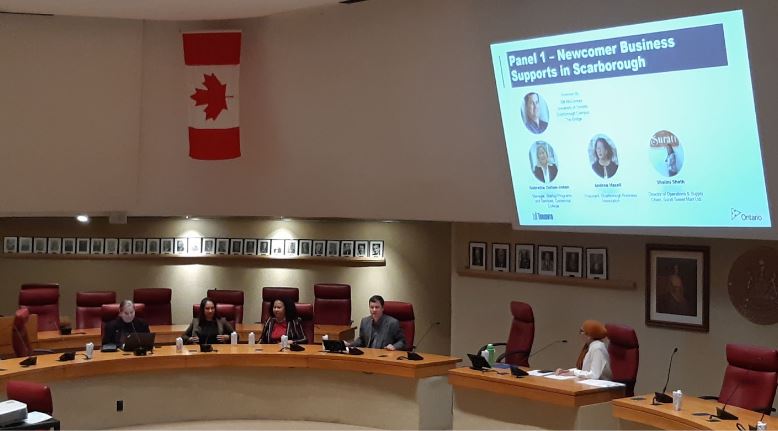 Panelists sitting at a large round table in the council chamber at the Scarborough Civic Centre.