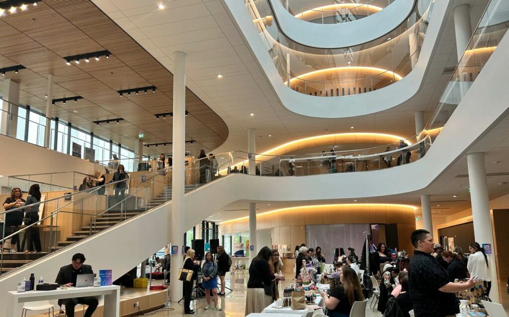 Participants at the event venue with a large open space and stair cases.