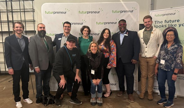 A diverse group of 10 people pose in front of a large Futurpreneur photo-op banner.