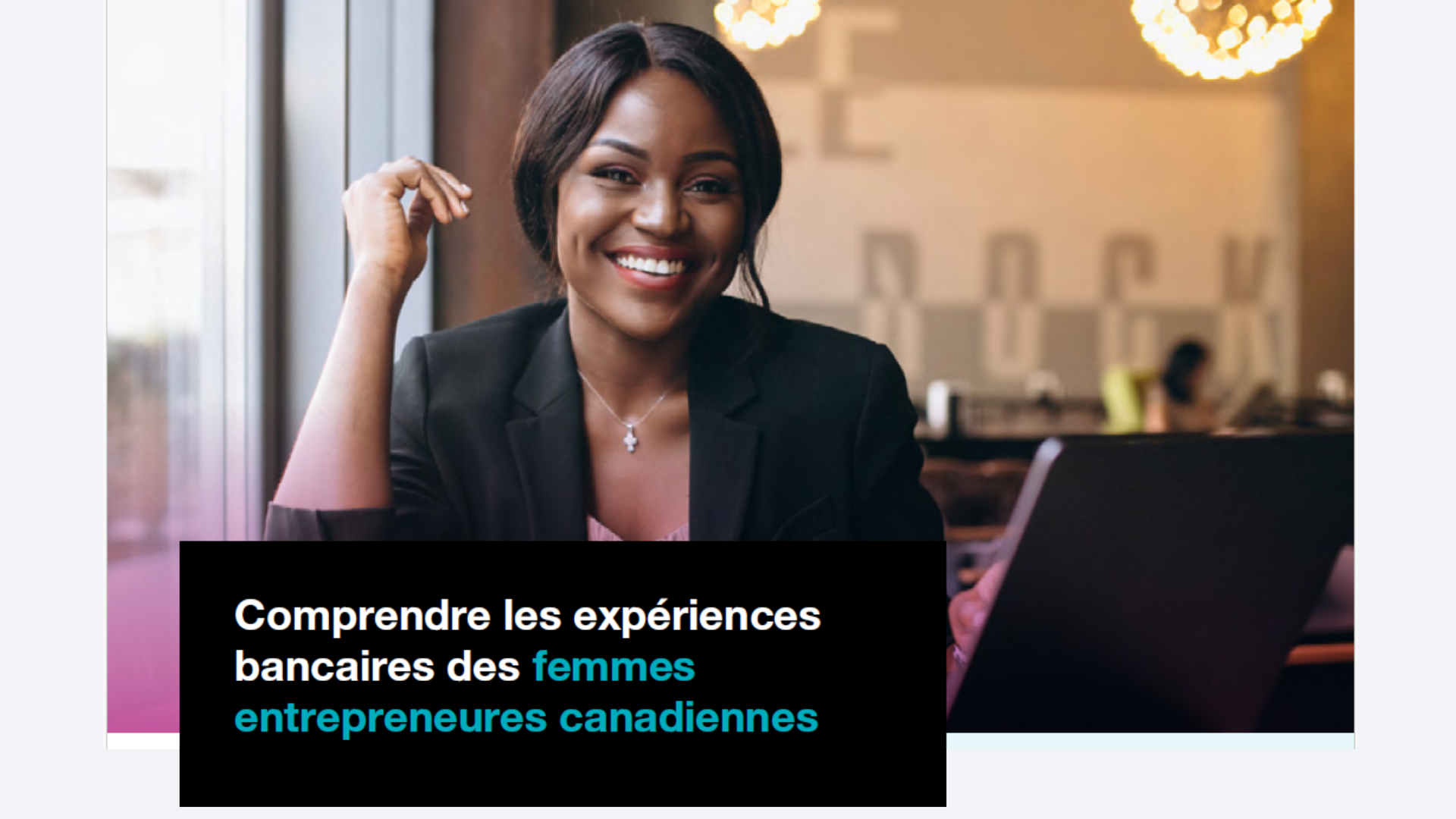 A Black woman professional smiling at the camera while sitting behind a desk.